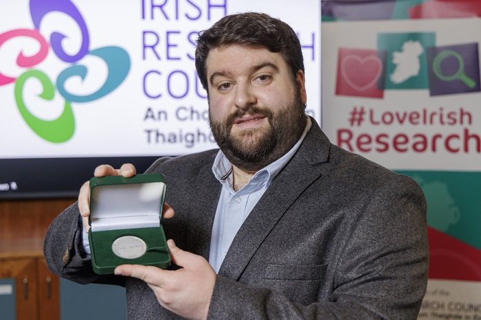 A portrait photo of Conway Fellow Dr Carlos Matellan hold his IRC award